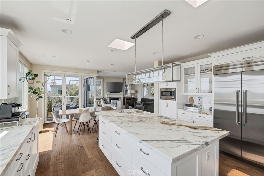 124 23rd Street Manhattan Beach, CA 90266 - Photo 9 of 50 a large kitchen with kitchen island a large counter space a sink appliances and living room view