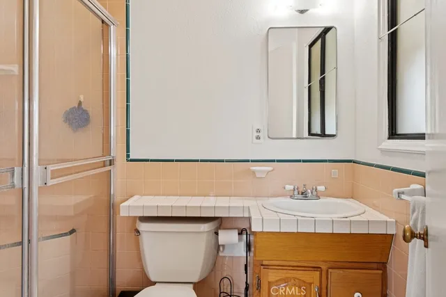 a bathroom with a sink a toilet and mirror