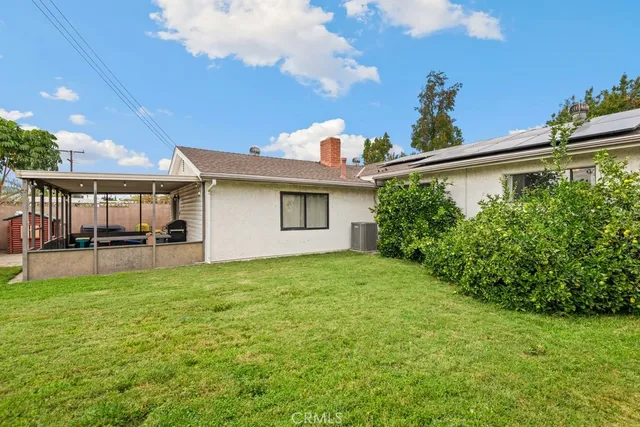 a view of a house with backyard and sitting area