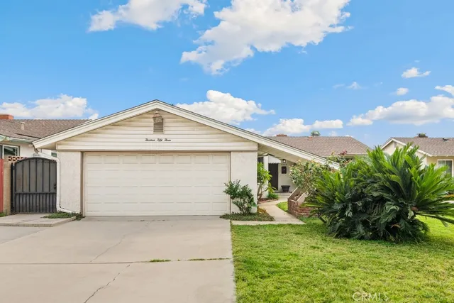 front view of house with a yard and potted plants
