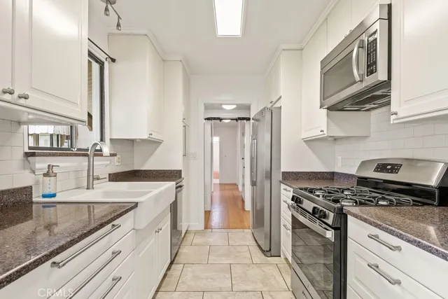 a kitchen with stainless steel appliances granite countertop a sink stove and cabinets