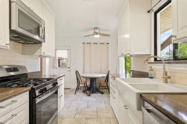 a kitchen with stainless steel appliances granite countertop a sink and a stove