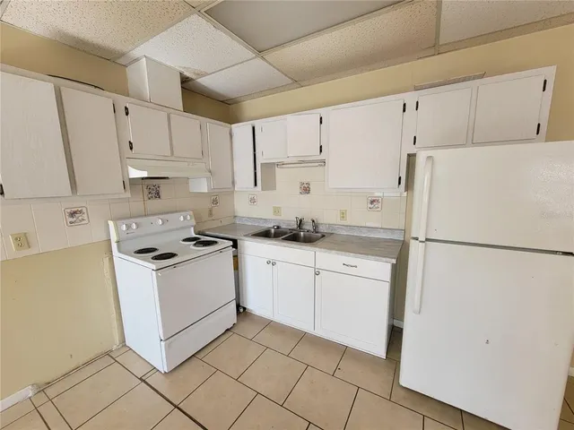 a kitchen with cabinets stainless steel appliances and sink