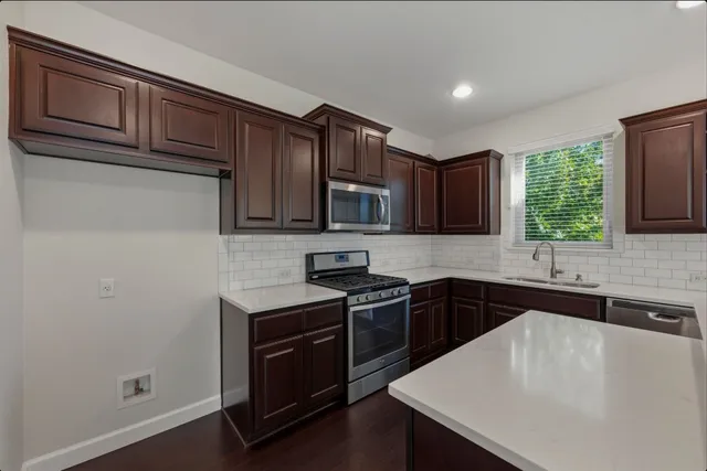 a kitchen with stainless steel appliances granite countertop a sink stove and refrigerator