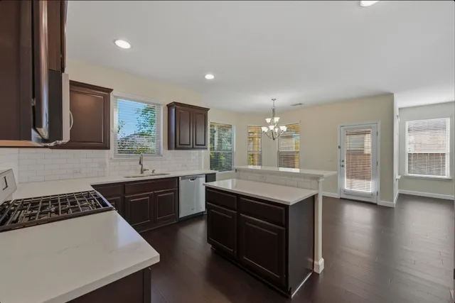 a kitchen with a sink stove top oven and refrigerator