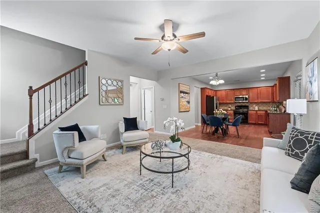 a kitchen with stainless steel appliances granite countertop a refrigerator a stove a sink dishwasher a dining table and chairs with wooden floor