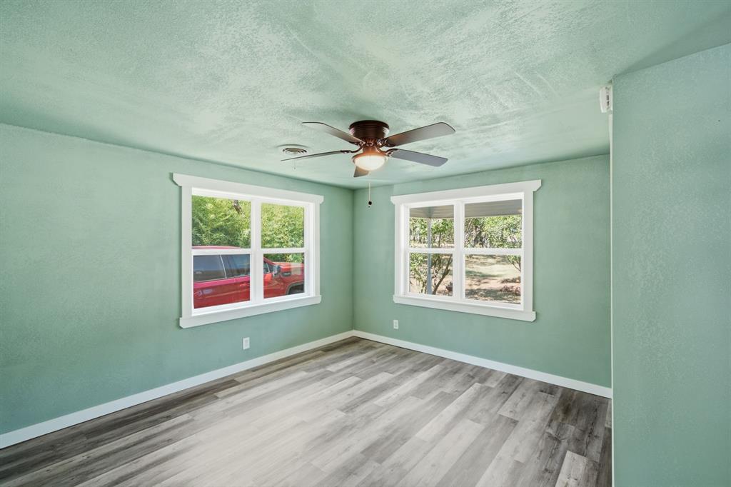 3325 Dove Creek Road Cleburne, TX 76031 - Photo 16 of 40 Interior room featuring wood-finish flooring and light green walls