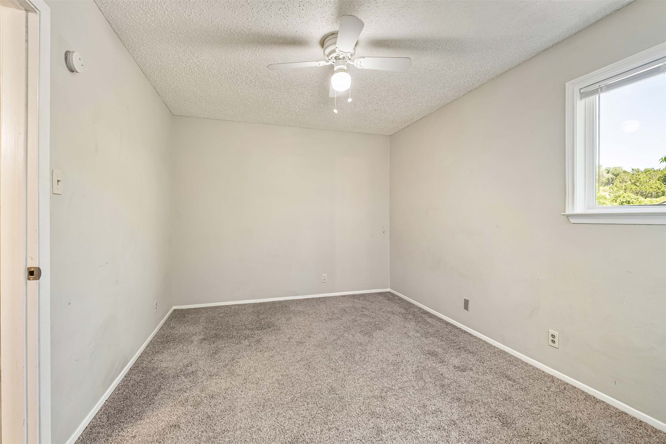 3904 Hudson Bend Road, Unit A Austin, TX 78734 - Photo 11 of 23 Carpeted spare room featuring a textured ceiling and ceiling fan
