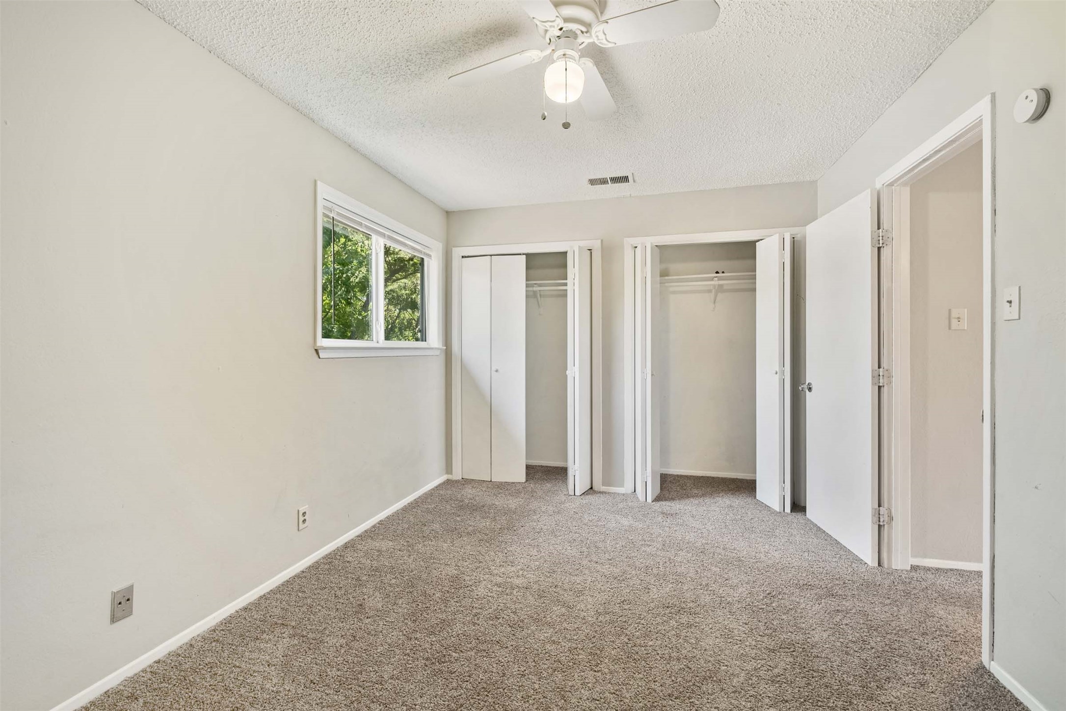 3904 Hudson Bend Road, Unit A Austin, TX 78734 - Photo 12 of 23 Unfurnished bedroom with two closets, carpet flooring, a textured ceiling, and ceiling fan