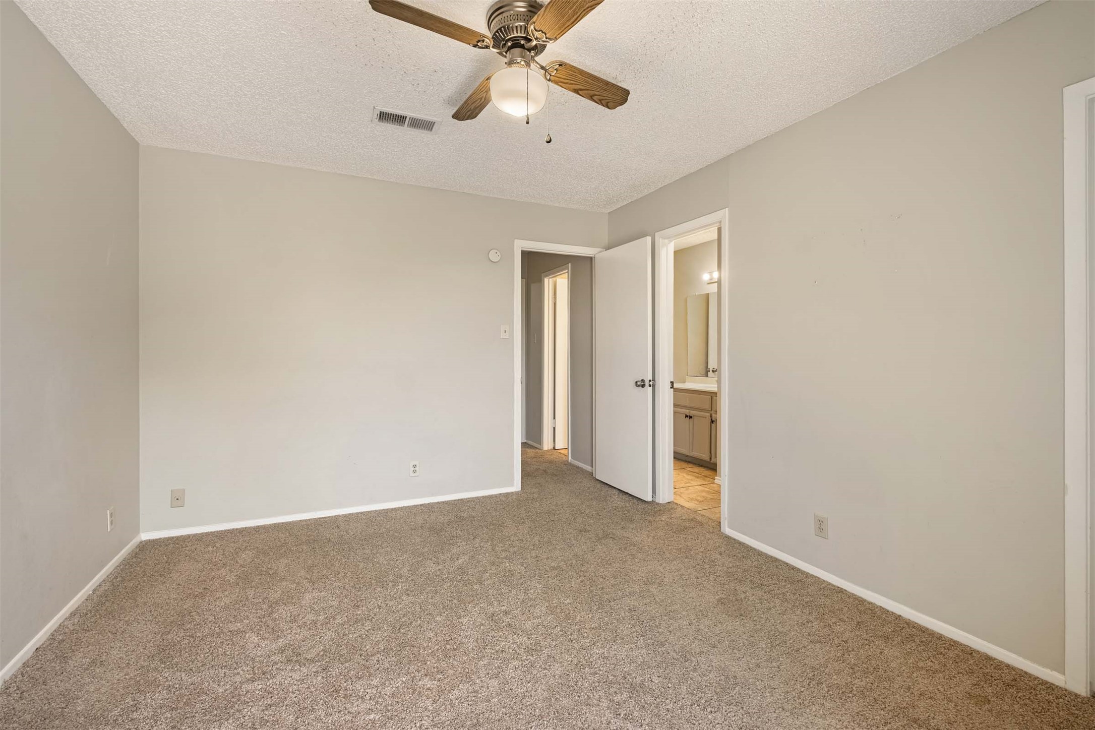 3904 Hudson Bend Road, Unit A Austin, TX 78734 - Photo 15 of 23 Unfurnished bedroom with carpet, a ceiling fan, a textured ceiling, and ensuite bathroom