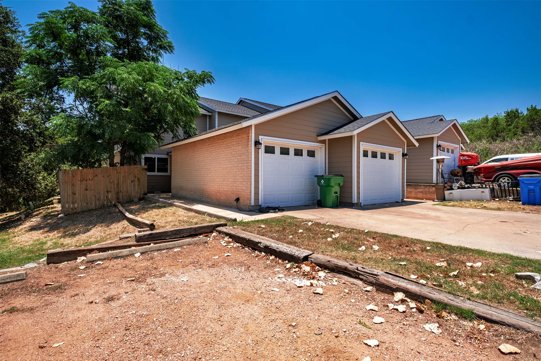 3904 Hudson Bend Road, Unit A Austin, TX 78734 - Photo 23 of 23 View of front facade featuring driveway, brick siding, a garage, and a shingled roof