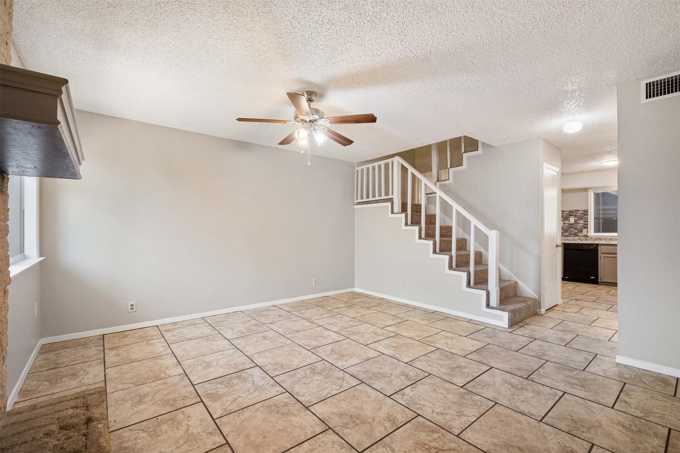 3904 Hudson Bend Road, Unit A Austin, TX 78734 - Photo 8 of 23 Unfurnished living room featuring a ceiling fan, a textured ceiling, and light tile patterned flooring