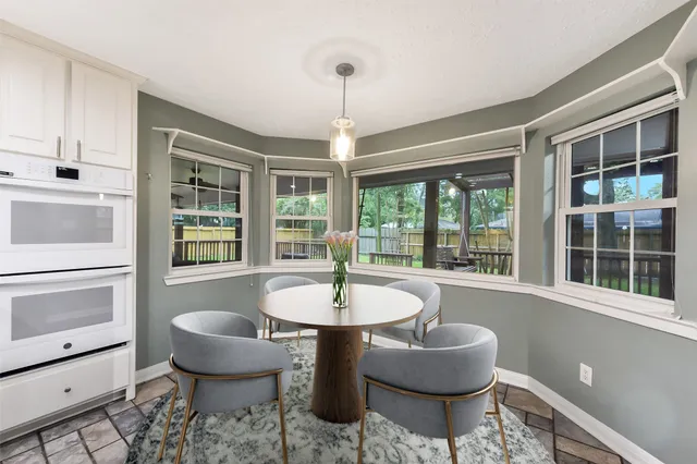 a dining room with furniture a chandelier and wooden floor