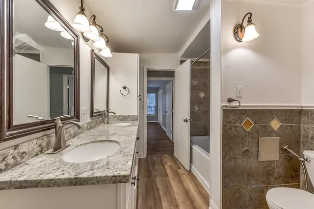 a bathroom with a granite countertop sink a mirror and shower