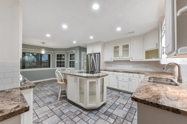 a kitchen with stainless steel appliances granite countertop a sink stove and cabinets