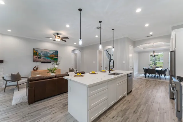 a view of a kitchen counter top space a sink appliances and wooden floor