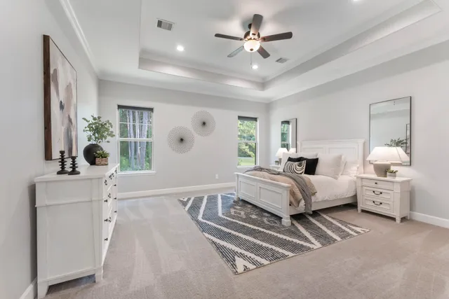 a spacious bedroom with a large bed and a chandelier
