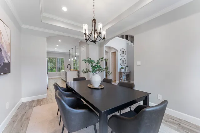a dining room with furniture a chandelier and wooden floor