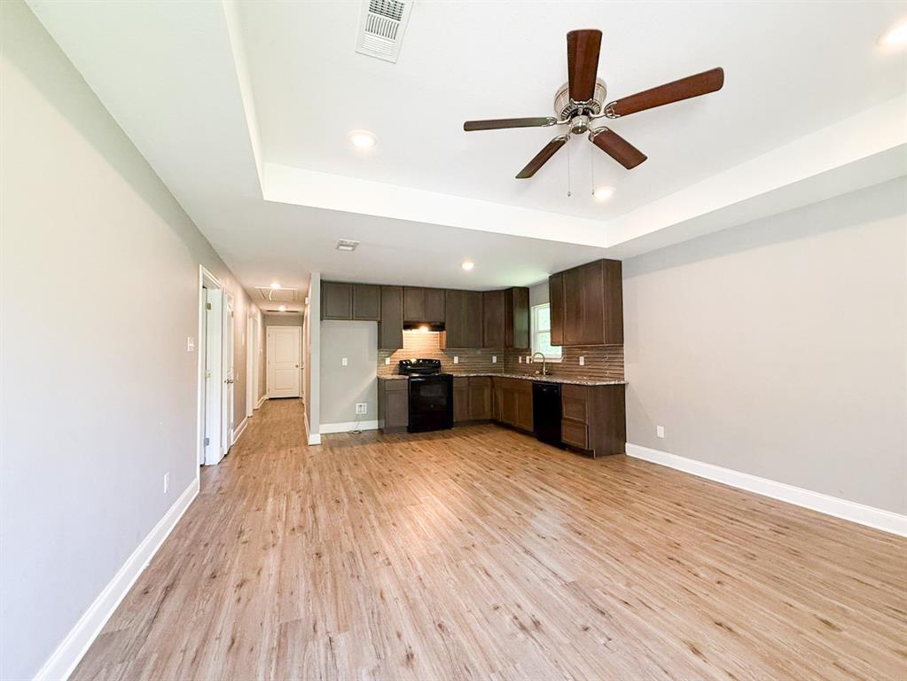 902 Cedar Street Commerce, TX 75428 - Photo 10 of 11 a view of a kitchen with a sink and wooden floor