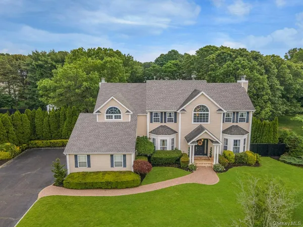 a view of a white house with a big yard and large trees