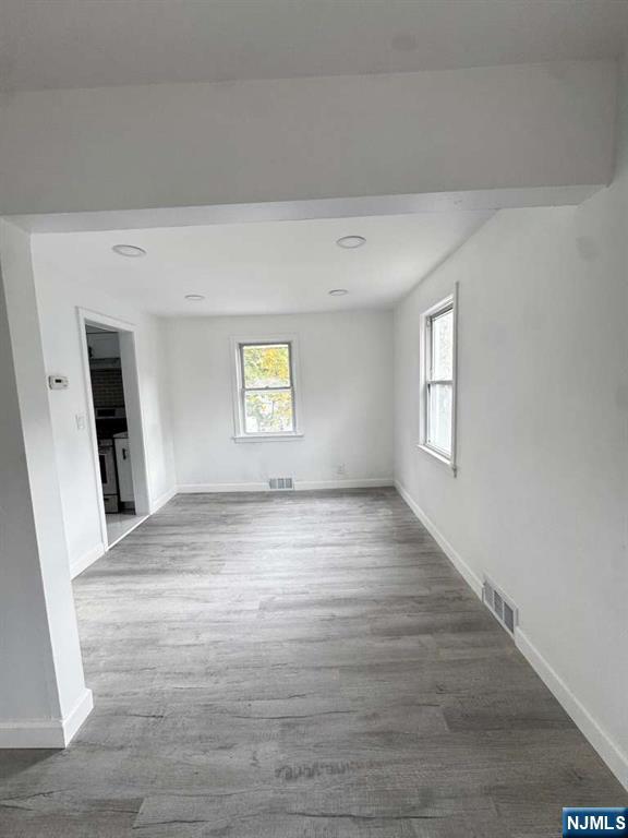 a view of empty room with window and wooden floor
