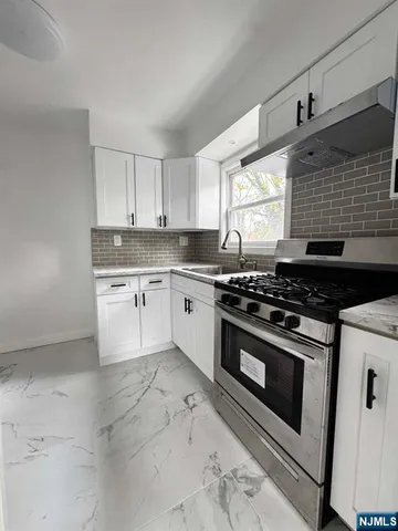 a kitchen with a stove a sink and a window