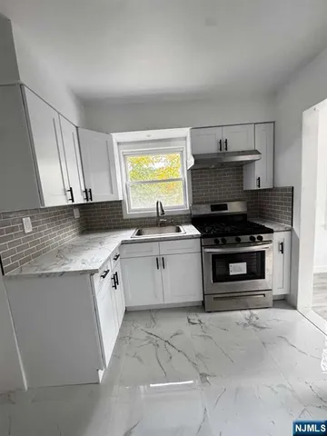 a kitchen with stainless steel appliances a stove a sink and a microwave