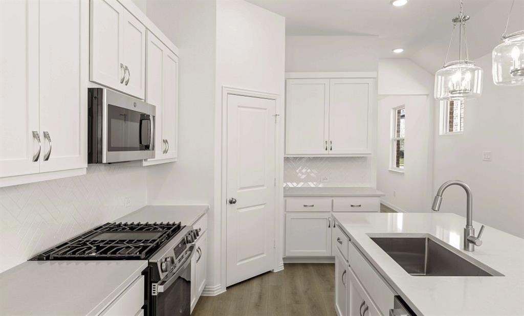 14200 Gallatin Street Pilot Point, TX 76258 - Photo 6 of 14 a kitchen with granite countertop a sink stove and cabinets