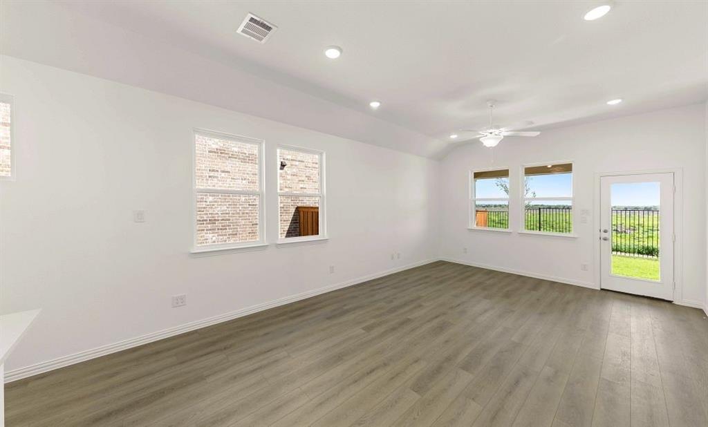 14200 Gallatin Street Pilot Point, TX 76258 - Photo 7 of 14 an empty room with wooden floor and windows