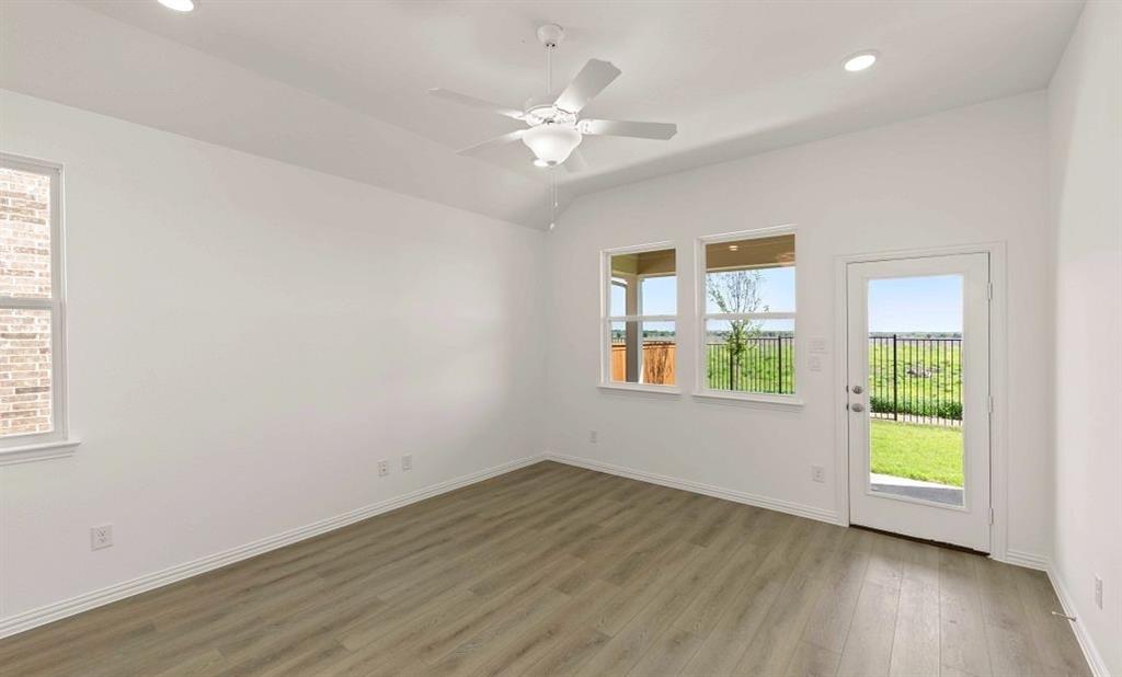 14200 Gallatin Street Pilot Point, TX 76258 - Photo 9 of 14 a view of an empty room with a window and wooden floor