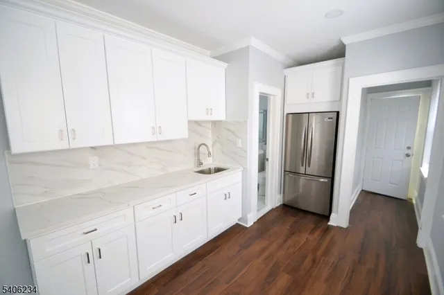 a kitchen with a refrigerator sink and cabinets