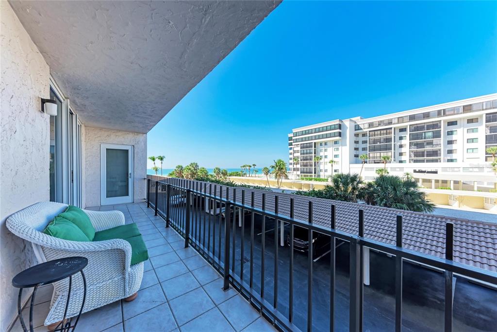 1212 Benjamin Franklin Drive, Unit 208 Sarasota, FL 34236 - Photo 20 of 32 a view of a balcony with chair and wooden floor