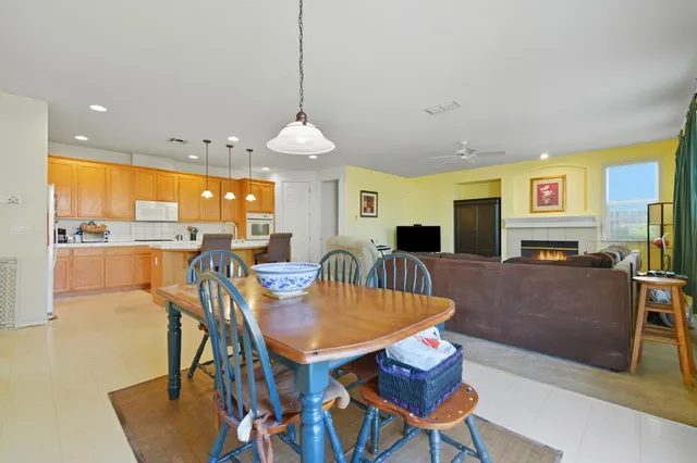 a view of a dining room with furniture a kitchen and chandelier