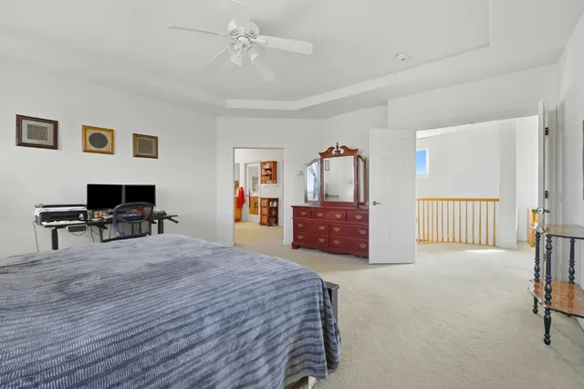 a spacious bedroom with a bed a desk and chair