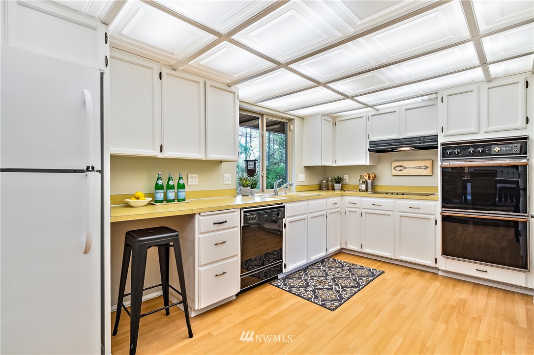 15713 Southeast 148th Street Renton, WA 98059 - Photo 13 of 39 a kitchen with stainless steel appliances granite countertop a stove a sink dishwasher and a refrigerator with wooden cabinets
