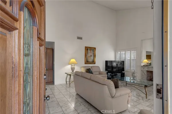 a living room with furniture a flat screen tv and a window