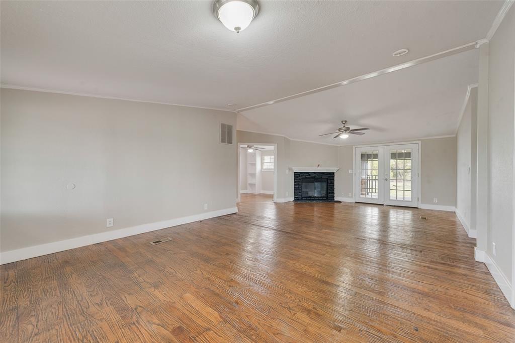 an empty room with wooden floor and fireplace