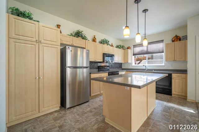 a kitchen with stainless steel appliances granite countertop a refrigerator a sink and a stove