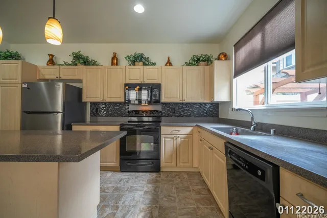 a kitchen with stainless steel appliances granite countertop a sink a stove and a refrigerator