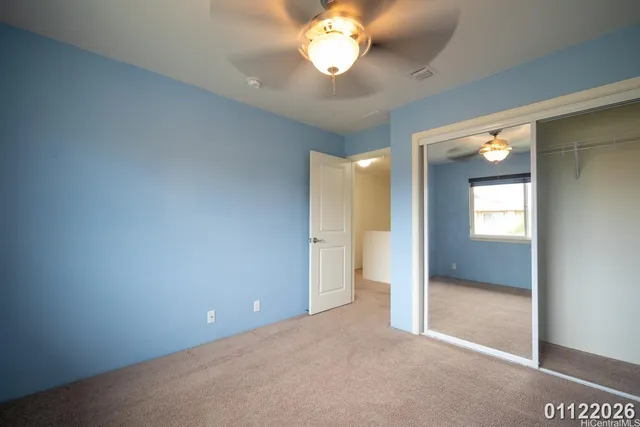 a view of an empty room with a chandelier fan