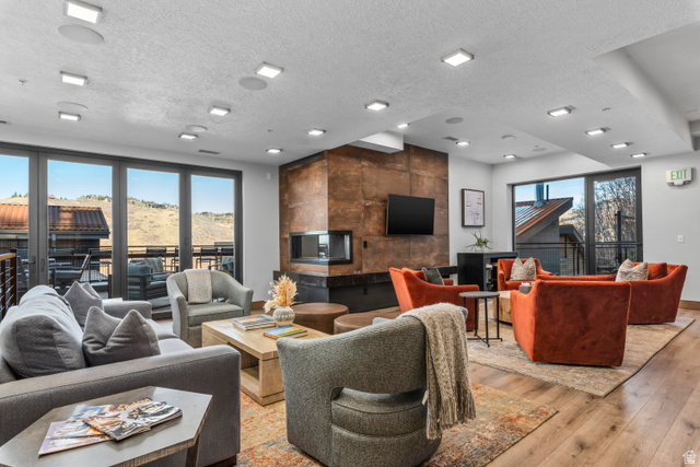 1258 Rothwell Road Park City, UT 84060 - Photo 43 of 48 Spacious common area featuring a modern fireplace with a distressed metal surround, wood-finish flooring, and ample recessed lighting