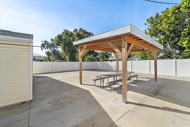 a view of backyard with a table and chair under an umbrella