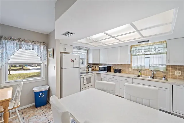 a kitchen with white cabinets and white appliances