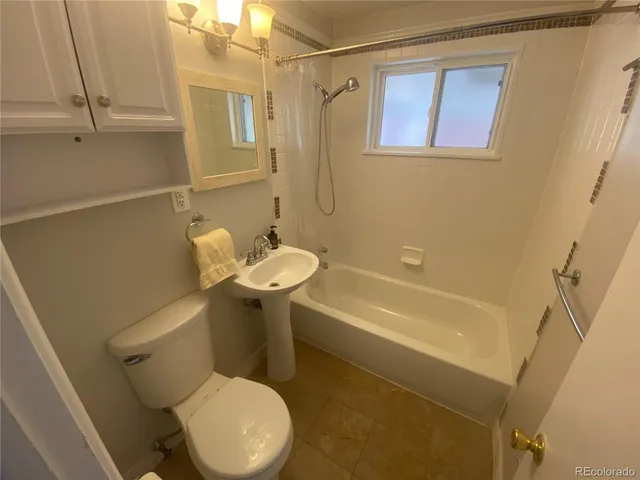 a white toilet sitting next to a bath tub