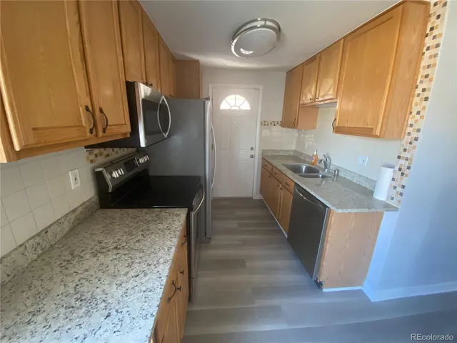 a kitchen with stainless steel appliances granite countertop a sink stove and refrigerator