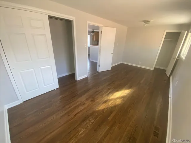 a view of empty room with wooden floor