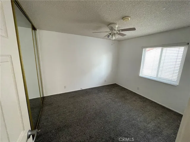 an empty room with windows and fan