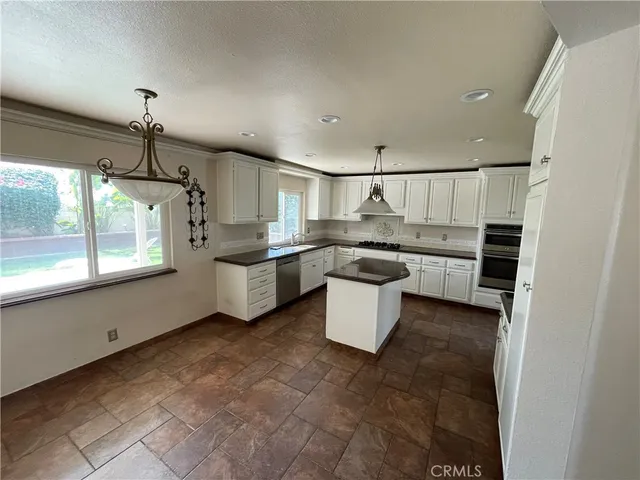 a kitchen with stainless steel appliances a sink a stove a refrigerator and cabinets