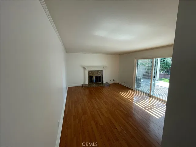 an empty room with wooden floor and fireplace