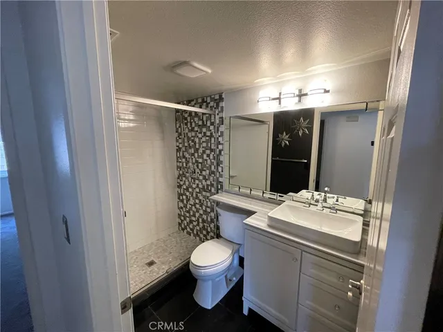 a bathroom with a sink toilet vanity and shower